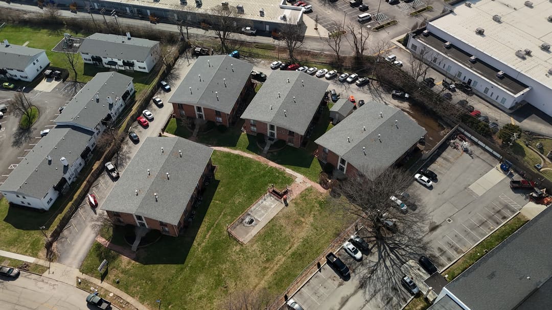 Shingle roofs across a block of apartment buildings, seen from the air