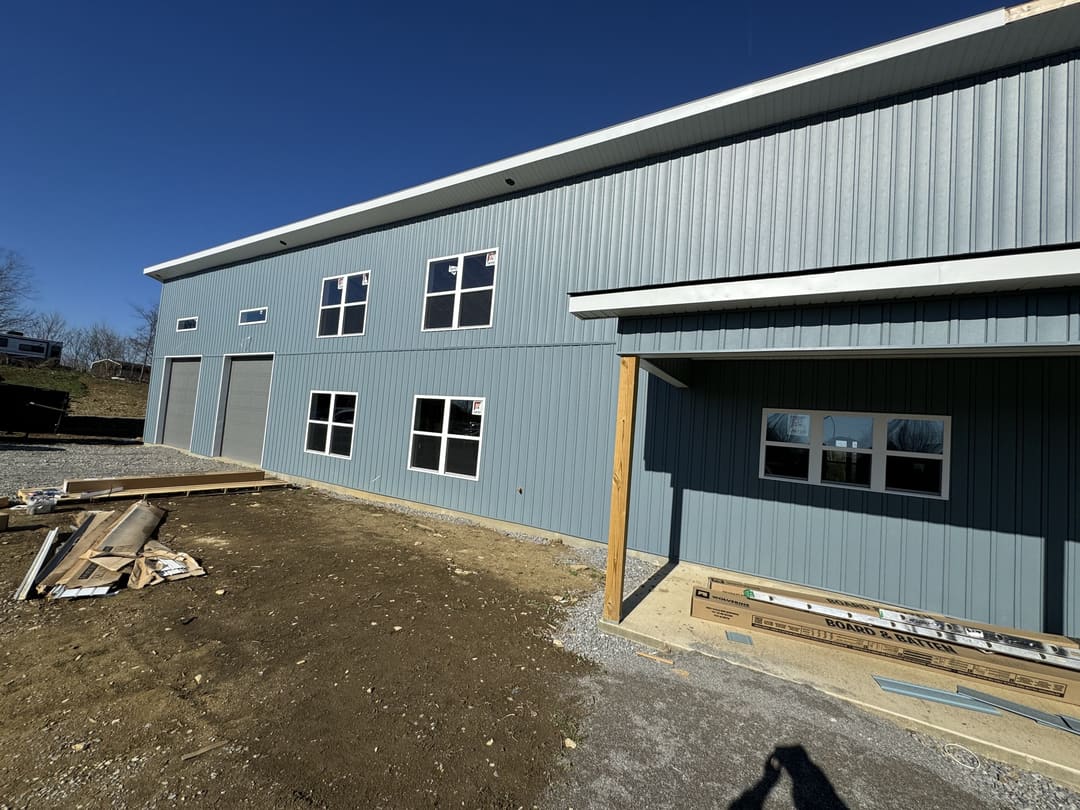 Porch side of a blue gray metal building during the build