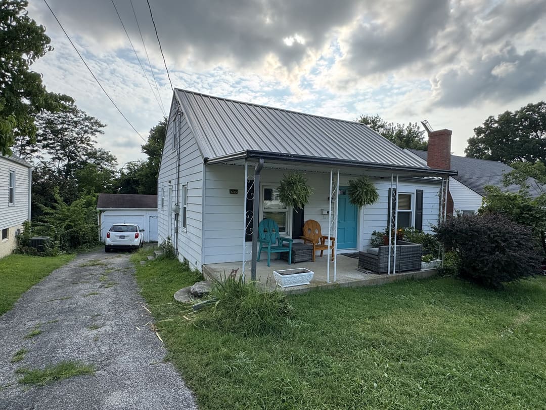 White bungalow with a silver metal roof and a front porch