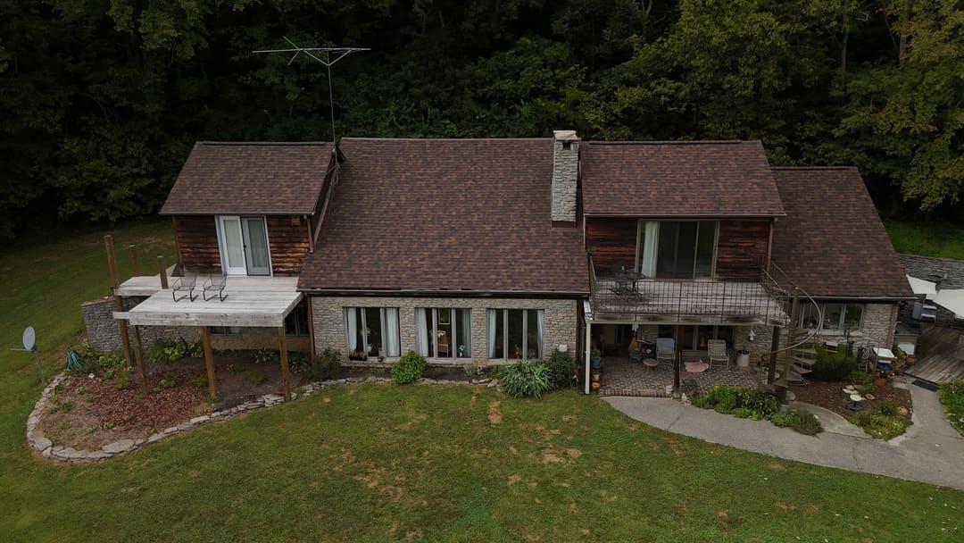 Front of a cedar and stone home with a new brown shingle roof