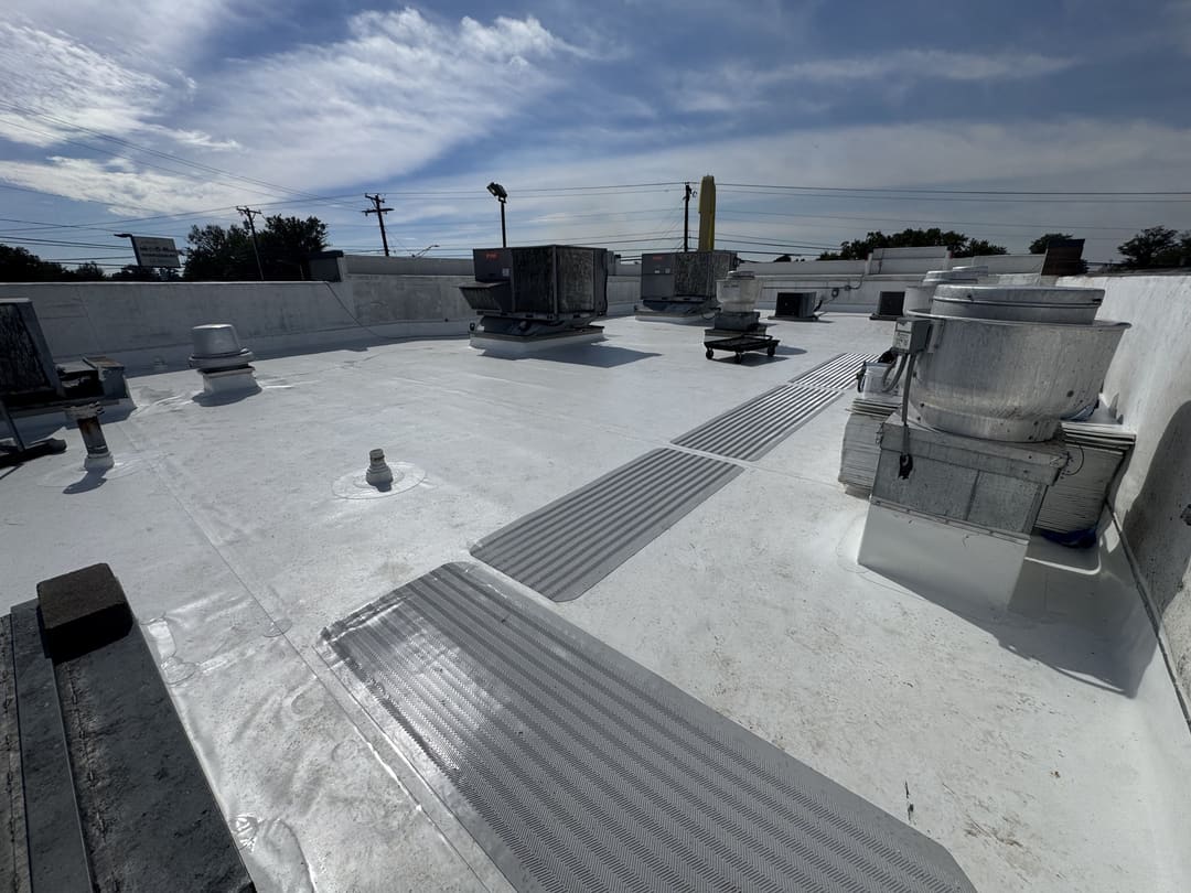 Low-slope membrane commercial roof with walkway pads around the rooftop units