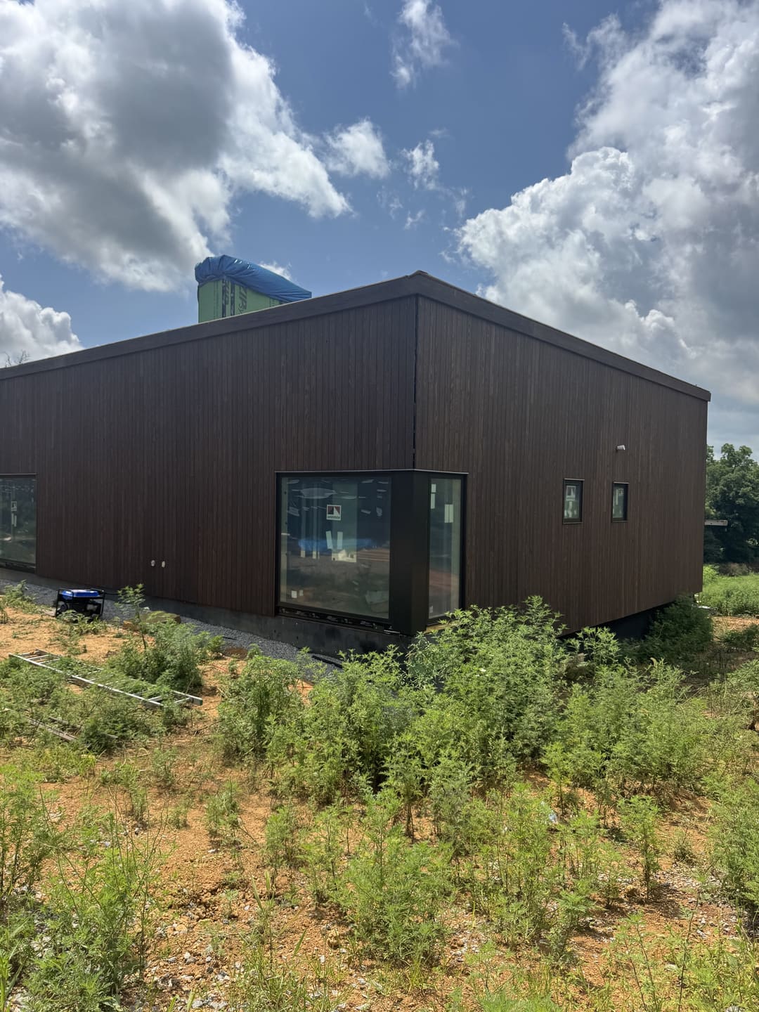 Dark wood siding on a modern home with a corner window