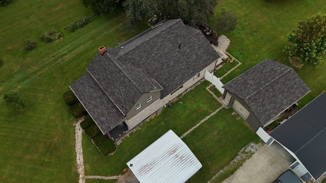 Gray shingle roof seen from straight above, next to a metal carport