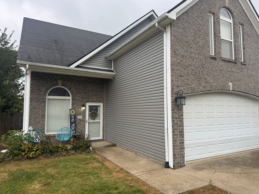 Norandex vinyl siding in Smoke with white trim beside the brick front of a two story home in Georgetown, KY