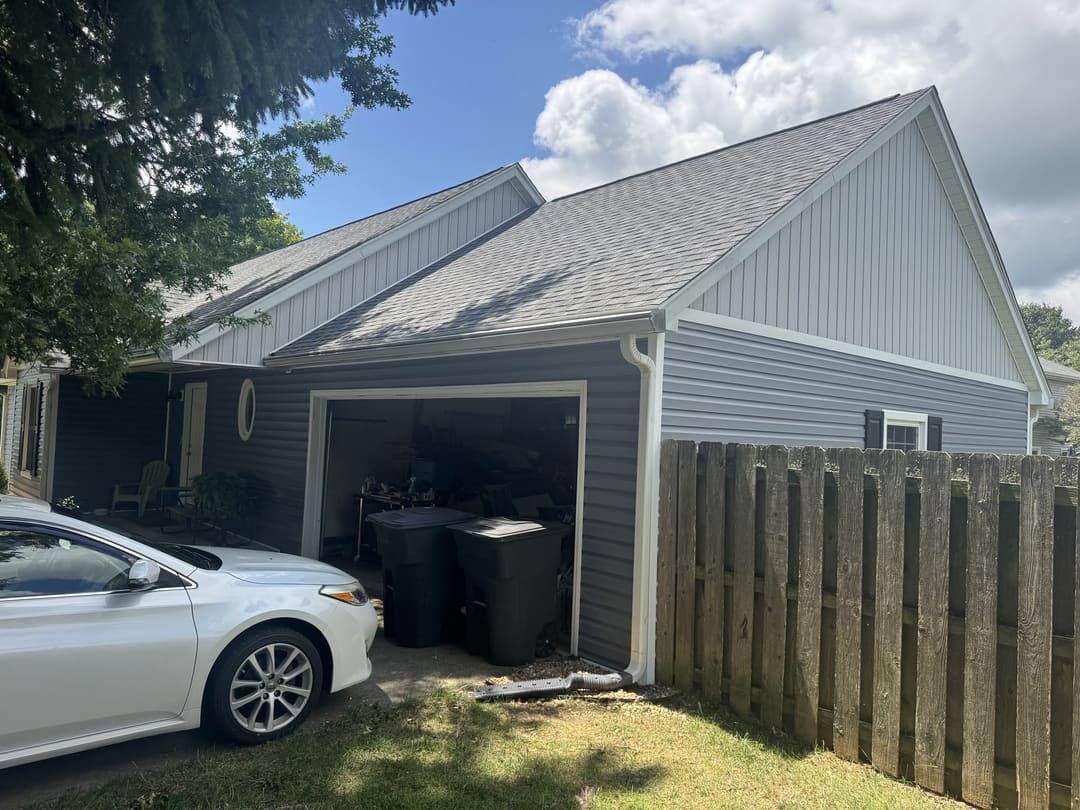 Gray vinyl siding and a white gable over the carport