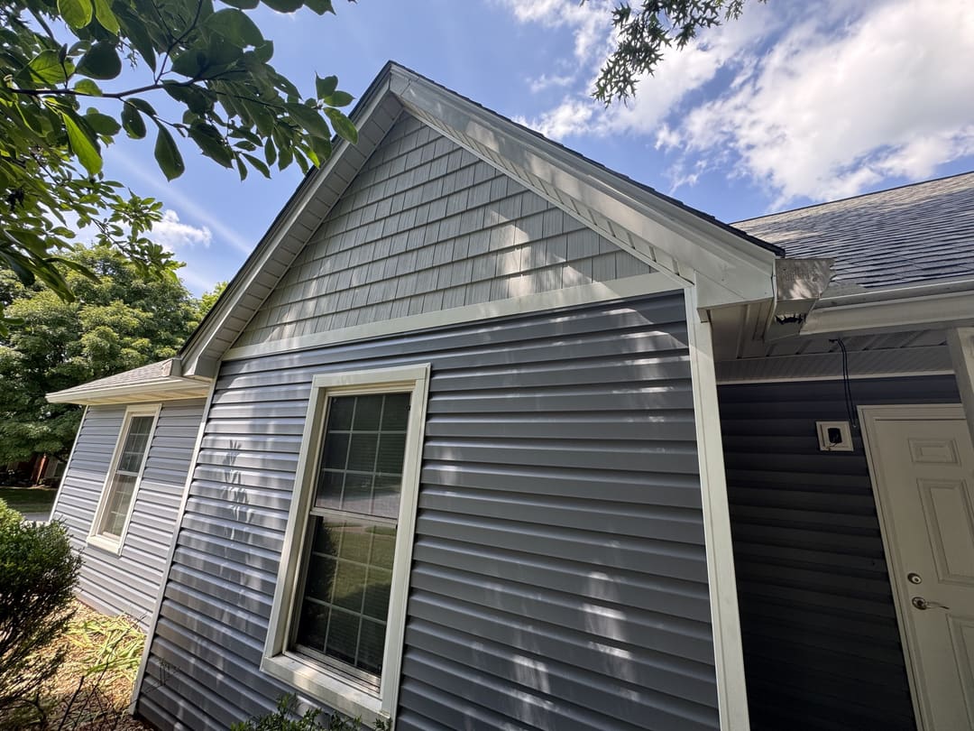 New gray vinyl siding and a white gable on a ranch home