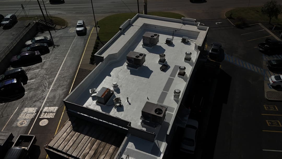 White membrane roof and rooftop units on a restaurant, seen from the air