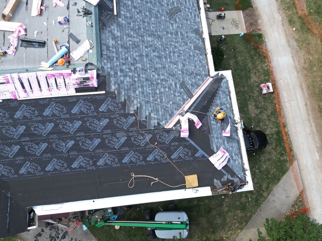 Underlayment and new shingles going down on a roof replacement